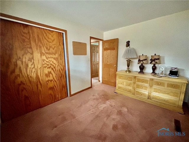 bedroom featuring light carpet, baseboards, and a closet