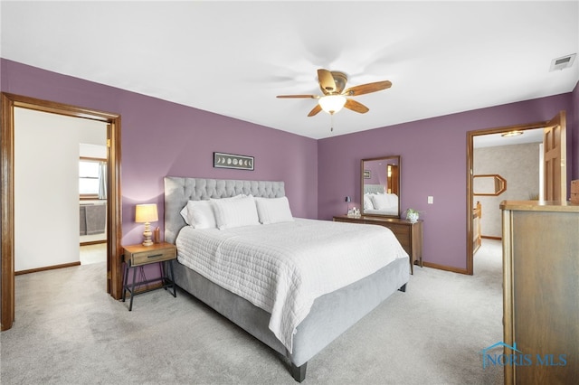 bedroom with baseboards, a ceiling fan, visible vents, and light colored carpet