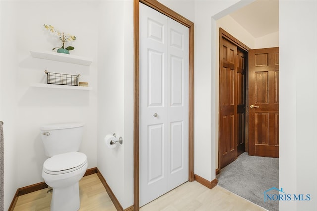 bathroom featuring toilet and baseboards