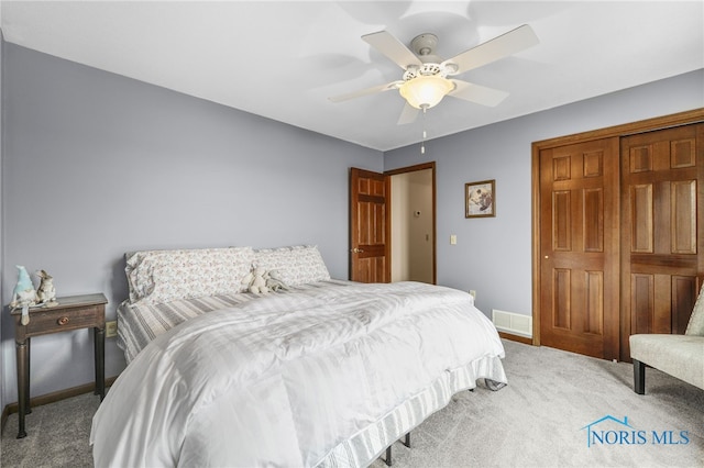 bedroom with ceiling fan, carpet flooring, visible vents, baseboards, and a closet