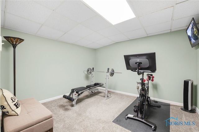 workout area with a paneled ceiling, baseboards, and carpet