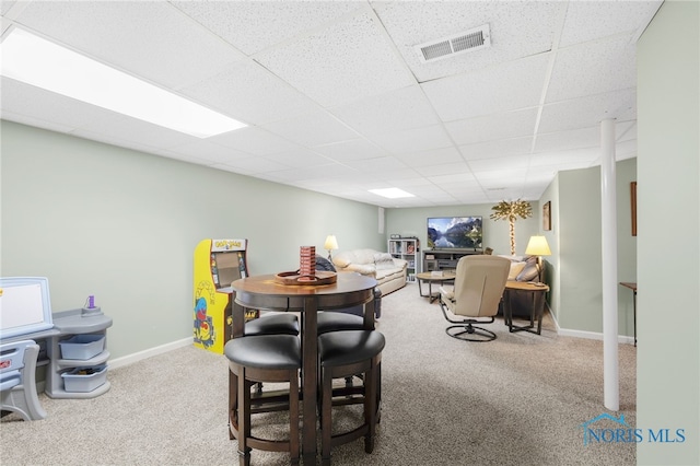 dining room featuring a drop ceiling, carpet, visible vents, and baseboards