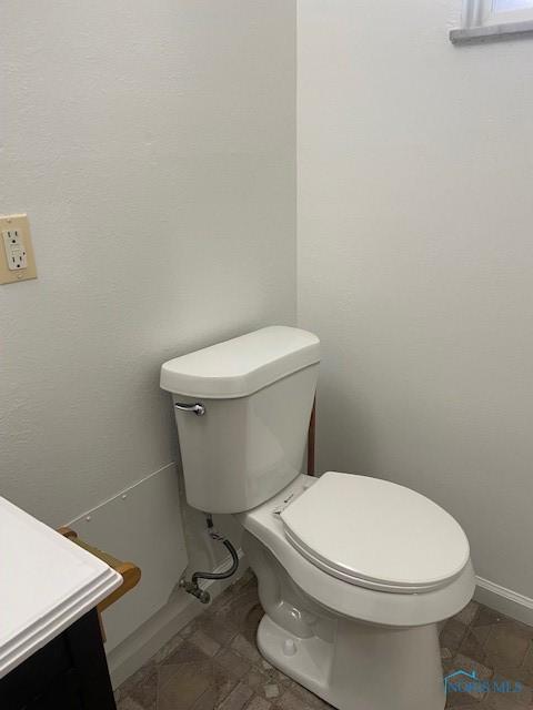 bathroom featuring baseboards and toilet