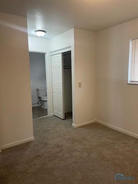 unfurnished room with carpet flooring and baseboards