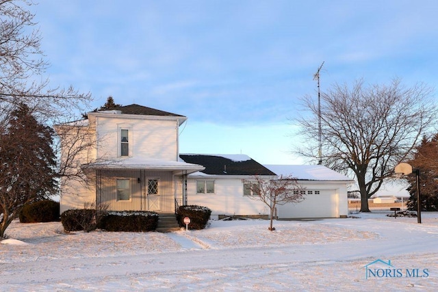 view of side of property with covered porch, driveway, and an attached garage