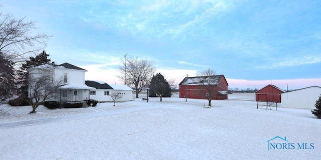 yard covered in snow featuring an outbuilding