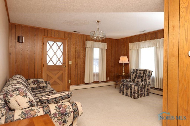 living area featuring visible vents, a baseboard heating unit, baseboard heating, and a wealth of natural light