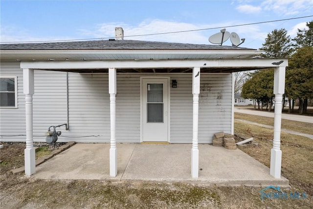 property entrance featuring a shingled roof