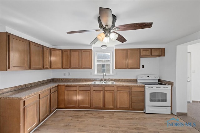 kitchen featuring ceiling fan, a sink, light wood-style floors, brown cabinetry, and white electric range oven