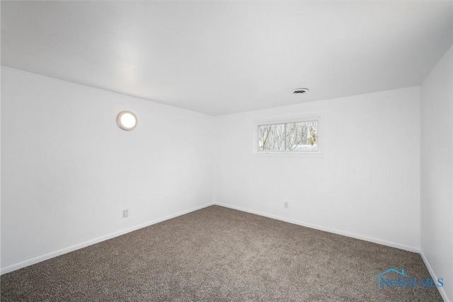 carpeted empty room with visible vents and baseboards