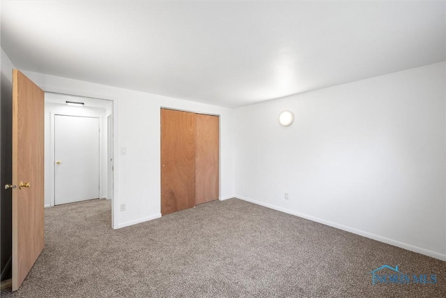 unfurnished bedroom featuring a closet, baseboards, and carpet flooring