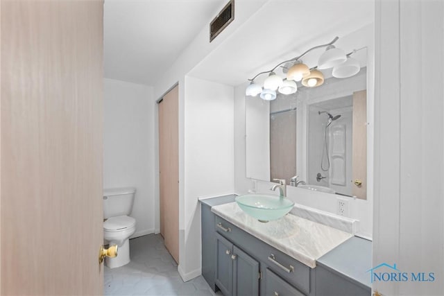 bathroom featuring toilet, vanity, visible vents, baseboards, and tile patterned floors