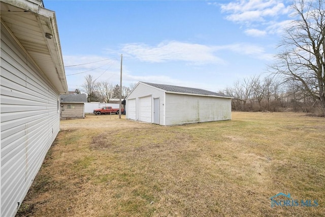 view of yard with an outdoor structure and a detached garage