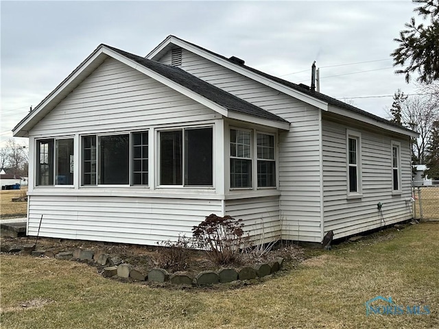 view of side of property with a yard and a sunroom