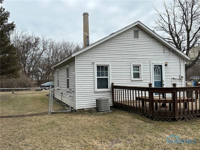 back of property with a gate, fence, a wooden deck, central air condition unit, and a lawn