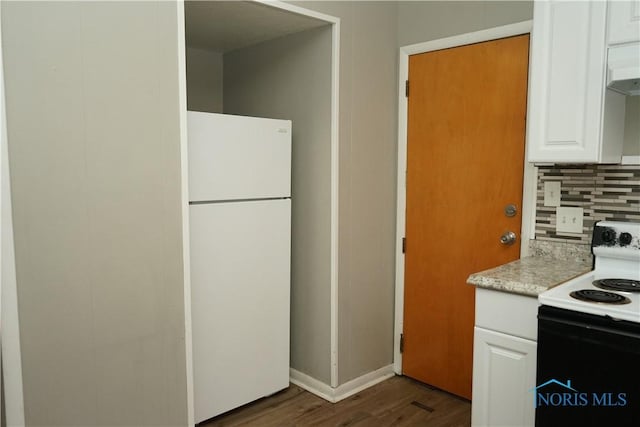 kitchen featuring tasteful backsplash, white cabinets, dark wood-type flooring, freestanding refrigerator, and range with electric stovetop