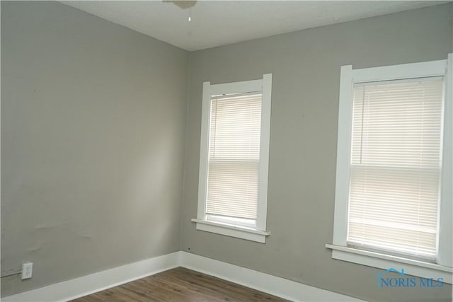 empty room with dark wood finished floors and baseboards