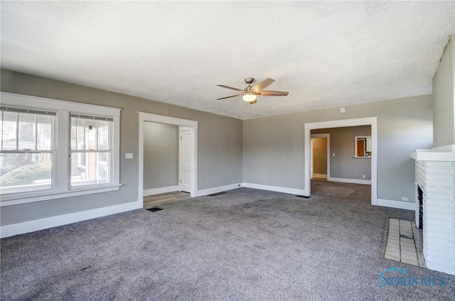 unfurnished living room with a textured ceiling, a fireplace, baseboards, and carpet