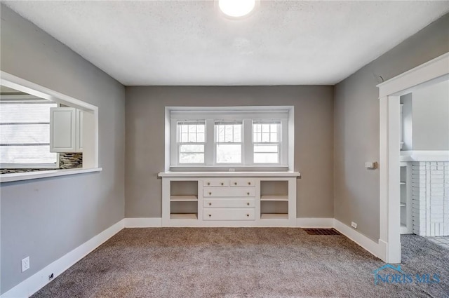 interior space with plenty of natural light, baseboards, and carpet