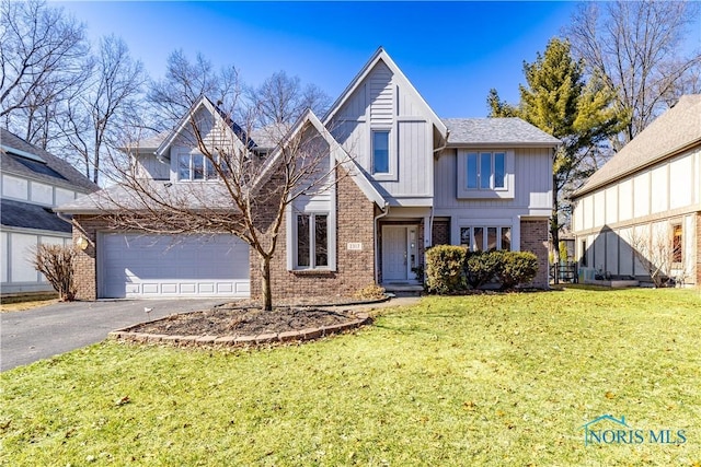 traditional-style home with driveway, board and batten siding, a front yard, an attached garage, and brick siding