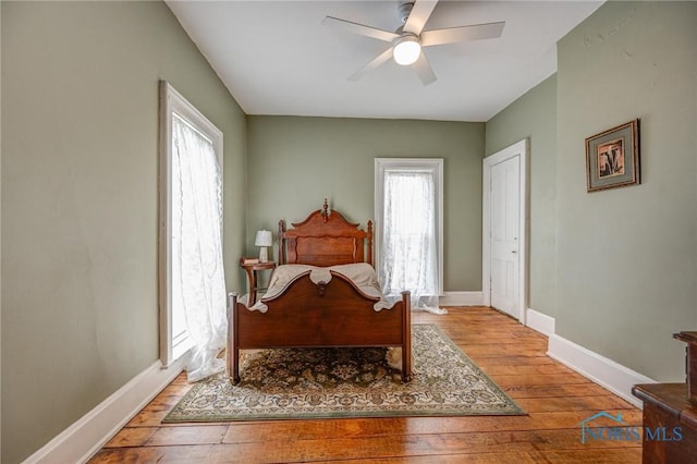 bedroom featuring baseboards, a ceiling fan, and hardwood / wood-style flooring