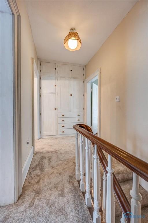 hallway with baseboards and carpet