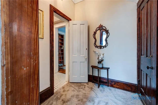 foyer with carpet floors and baseboards