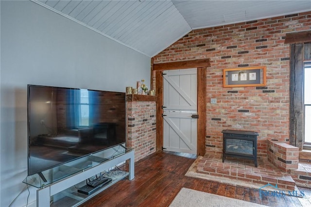 living area with lofted ceiling, a barn door, wooden ceiling, a wood stove, and wood finished floors