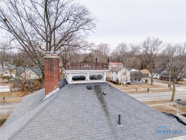 details with a chimney and roof with shingles