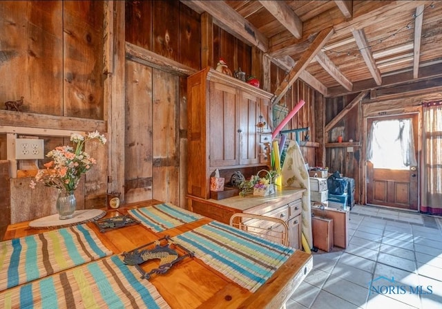 interior space featuring wooden ceiling, wood walls, and beam ceiling