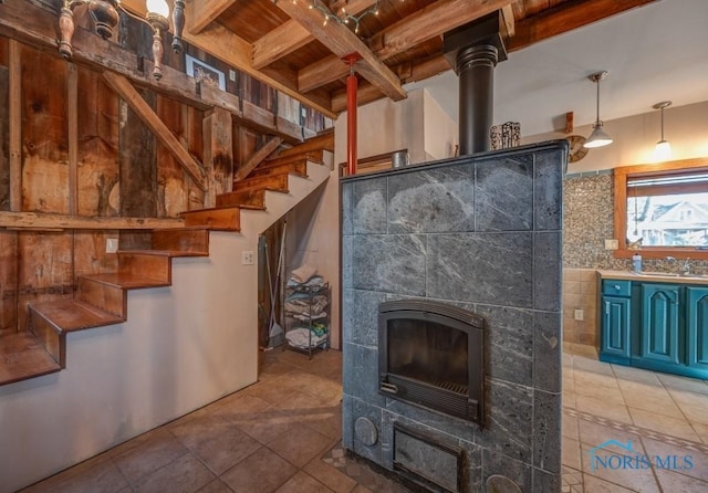 unfurnished living room with stairway, beam ceiling, wood ceiling, and tile patterned floors