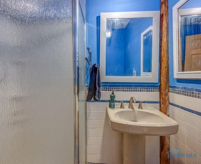 bathroom with tile walls and a stall shower