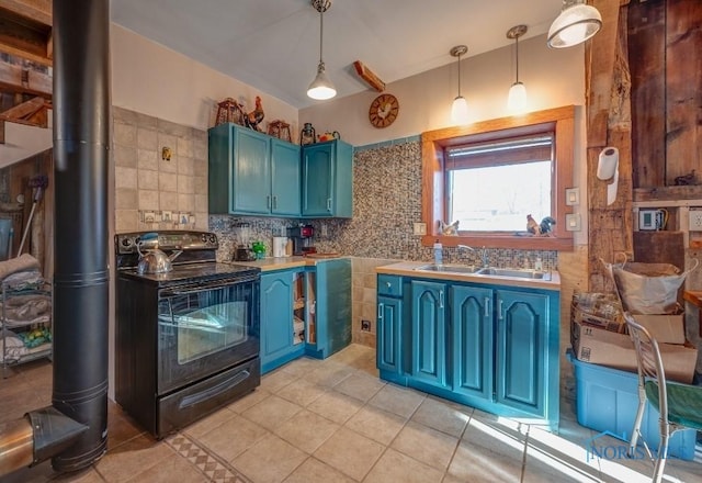 kitchen with a wood stove, a sink, light tile patterned flooring, black electric range, and blue cabinets