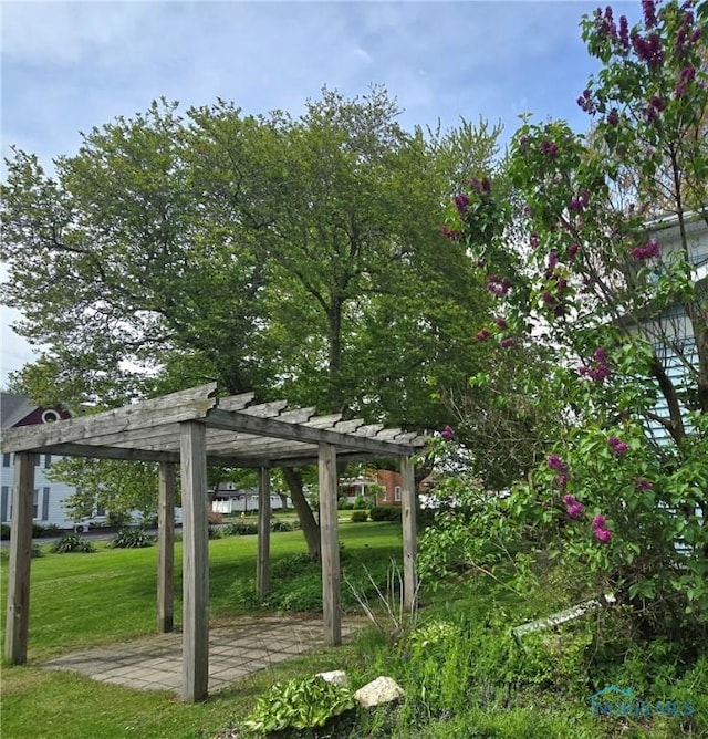 view of home's community with a yard and a pergola