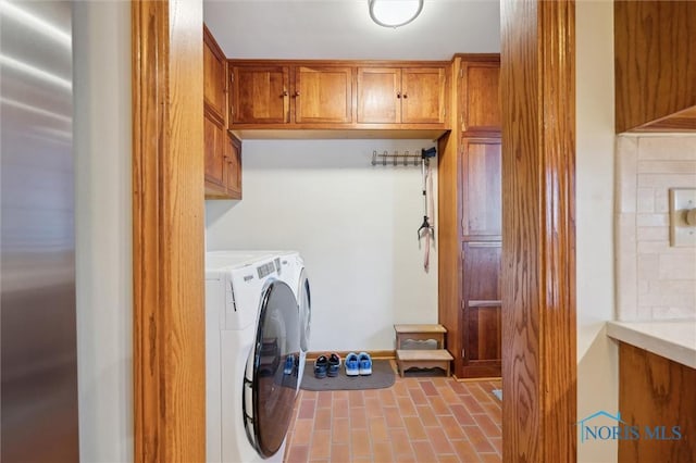 clothes washing area with cabinet space and separate washer and dryer