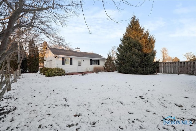 snow covered house with fence