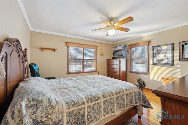 bedroom with a ceiling fan, crown molding, baseboards, and wood finished floors