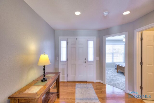 foyer entrance with recessed lighting, light wood-type flooring, and baseboards