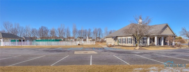 uncovered parking lot featuring fence