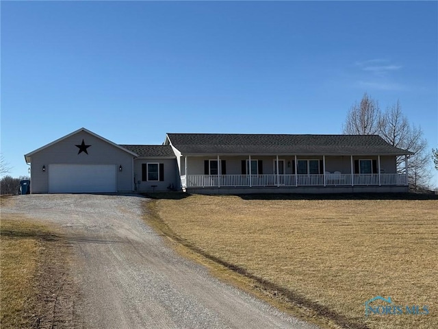 ranch-style house featuring a porch, an attached garage, a front yard, and driveway