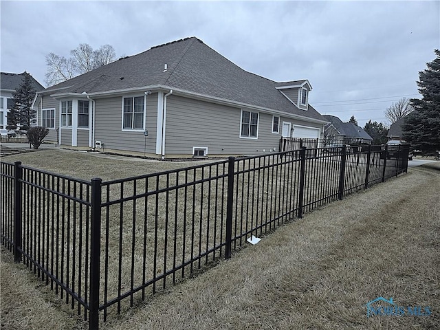 view of property exterior with a fenced backyard, an attached garage, and roof with shingles