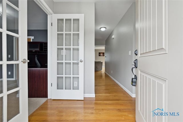 entryway with light wood-type flooring and baseboards