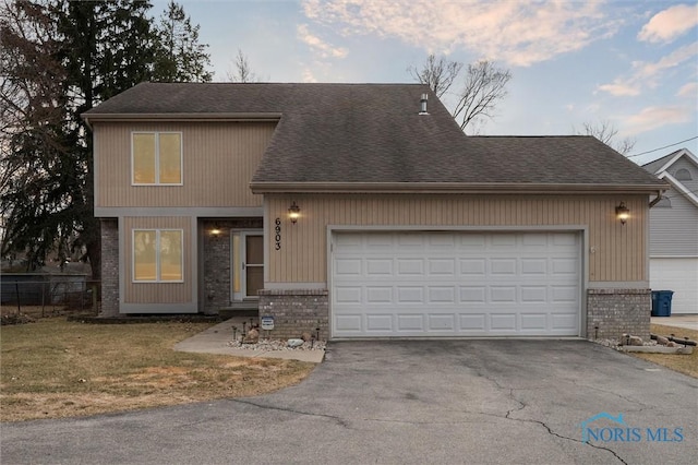 view of front of property featuring an attached garage, roof with shingles, aphalt driveway, and brick siding