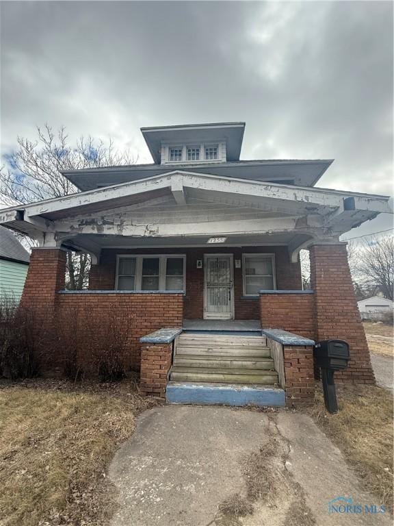 view of front of house with covered porch and brick siding