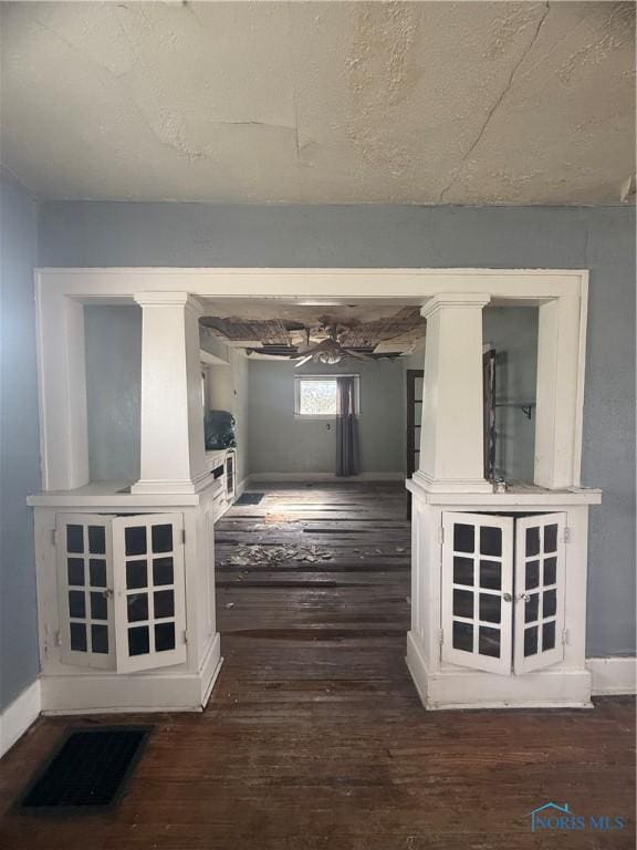 hallway featuring visible vents, baseboards, and wood finished floors