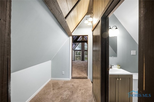 bonus room featuring carpet floors, vaulted ceiling with beams, baseboards, and a sink