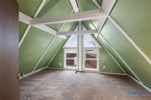 additional living space featuring vaulted ceiling with beams, wood walls, and carpet flooring