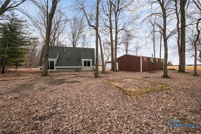 rear view of property featuring an outbuilding