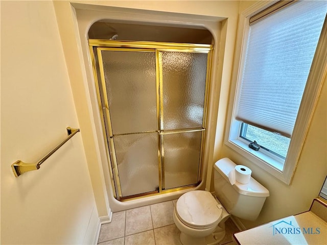 bathroom featuring toilet, a shower stall, and tile patterned flooring