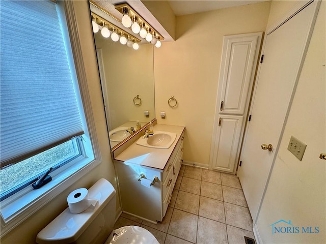 bathroom with vanity, baseboards, and tile patterned floors